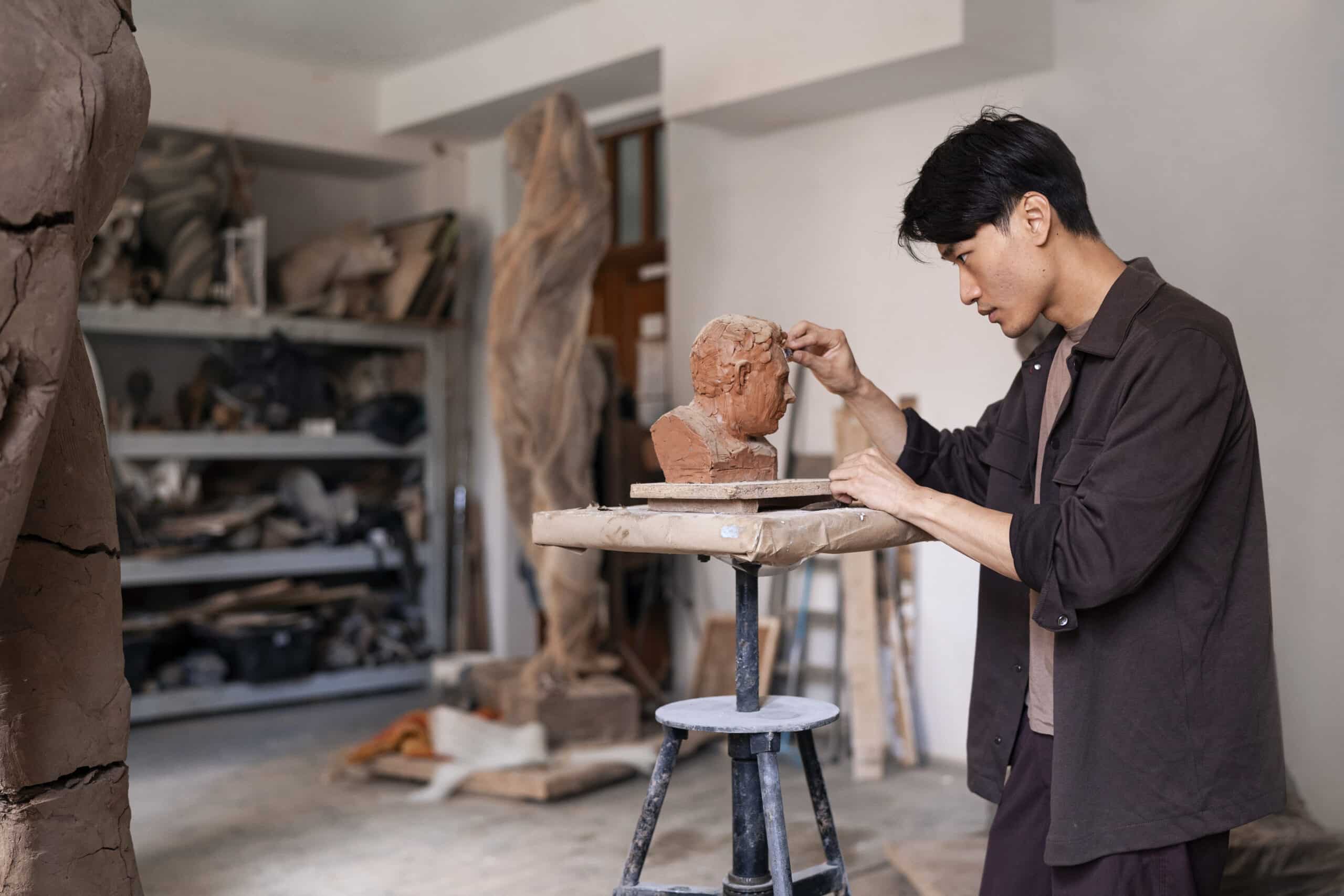 young man clay sculpting medium shot scaled