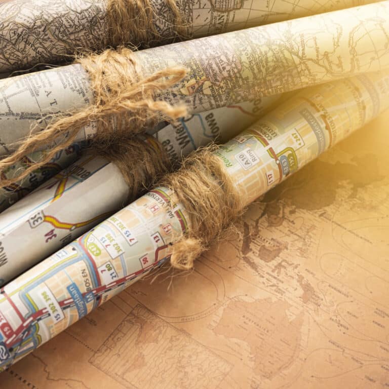 Cartes anciennes pliées et roulées, plis marqués sur un papier jauni