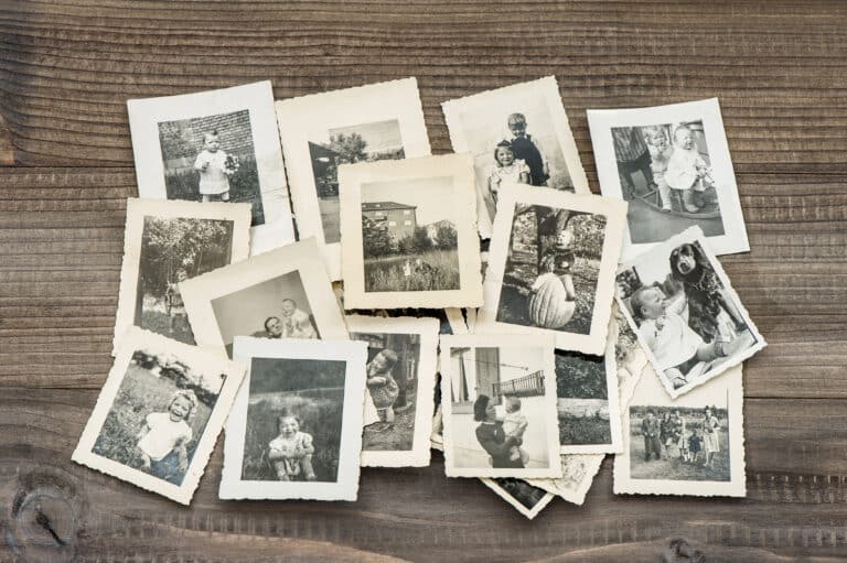 Tirages photographiques anciens en noir et blanc étalés sur une table en bois